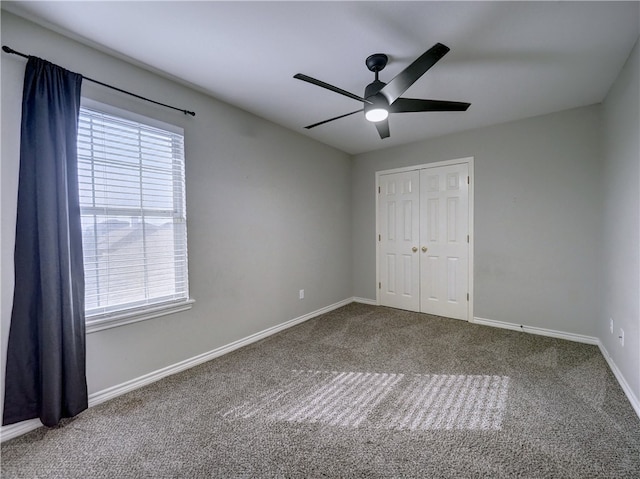 unfurnished bedroom with a closet, carpet, and ceiling fan