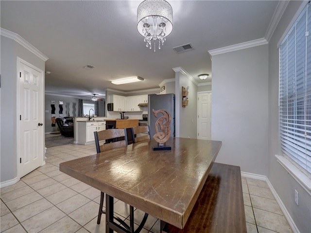 dining area featuring sink, light tile patterned flooring, and crown molding