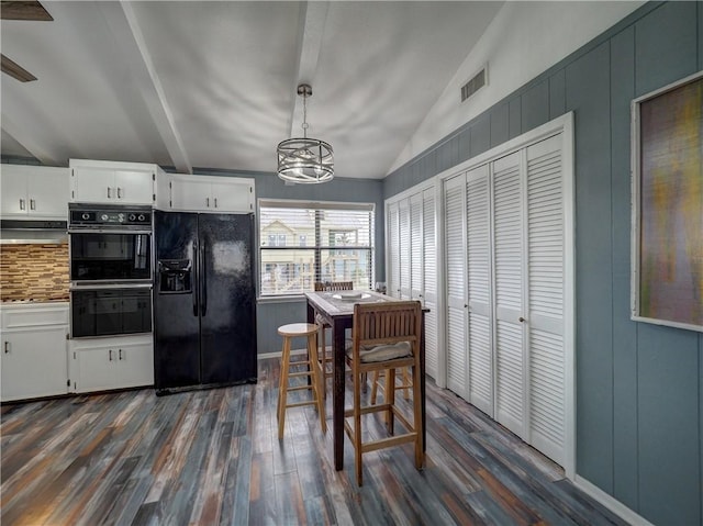 dining space featuring dark wood-type flooring, a chandelier, and lofted ceiling