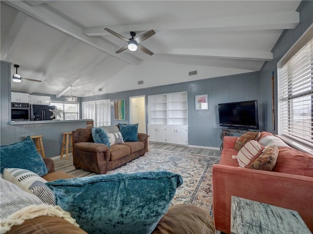 living room featuring wood finished floors, a ceiling fan, and wood walls