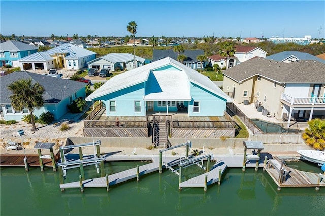 127 Sea Mist Dr, Aransas Pass, TX 78336 - dock featuring a residential view, boat lift, a water view, and a fenced backyard