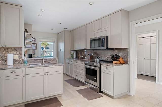 127 Sea Mist Dr, Aransas Pass, TX 78336 - kitchen featuring stainless steel appliances, a sink, tasteful backsplash, light stone countertops, and recessed lighting