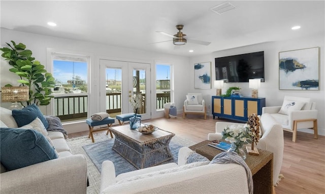 living room featuring ceiling fan, french doors, and light hardwood / wood-style flooring