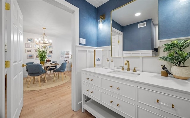 bathroom with a notable chandelier, wood-type flooring, and vanity