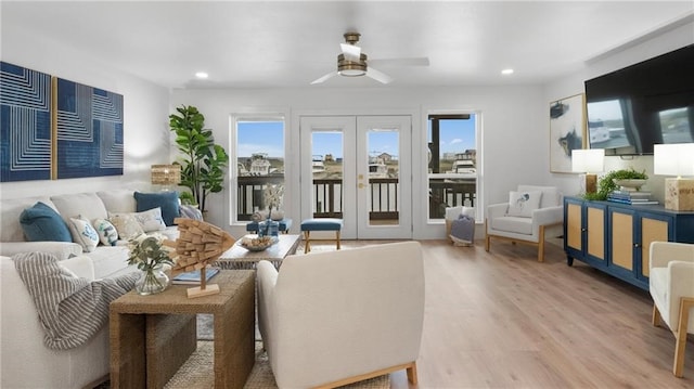 living room featuring ceiling fan, light hardwood / wood-style flooring, and french doors