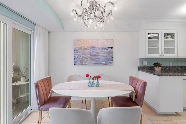 tiled dining space with ornamental molding, a healthy amount of sunlight, and a notable chandelier