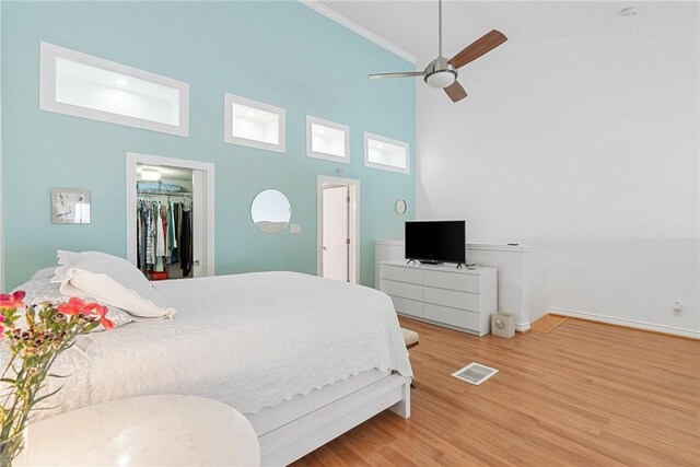 bedroom featuring a towering ceiling, a closet, a spacious closet, and ceiling fan