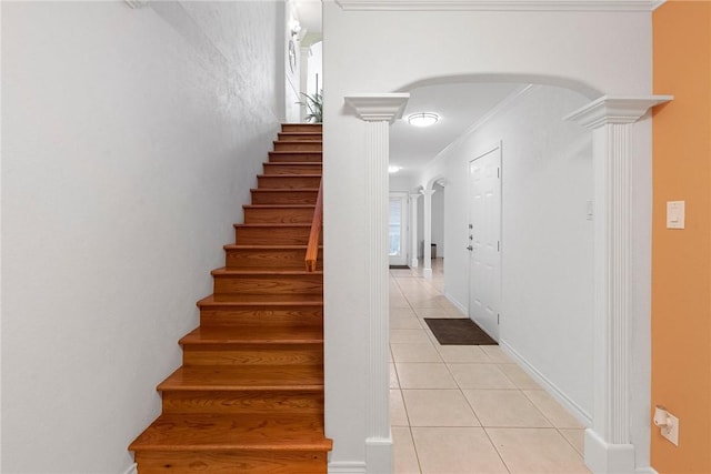 stairs featuring tile patterned floors, crown molding, and decorative columns