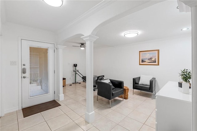 interior space with ceiling fan, ornate columns, crown molding, and light tile patterned floors