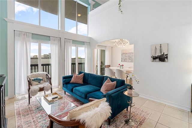 tiled living room with a high ceiling and a notable chandelier