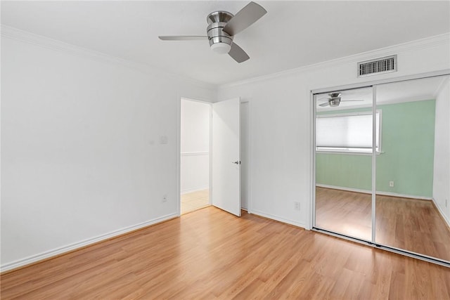 unfurnished bedroom featuring ceiling fan, a closet, crown molding, and light hardwood / wood-style flooring