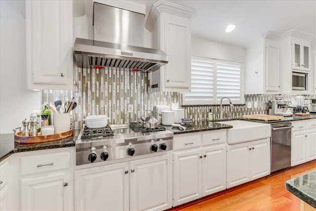5241 Saint Andrews Dr, Corpus Christi, TX 78413 - kitchen featuring wall chimney exhaust hood, stainless steel appliances, a sink, white cabinets, and backsplash