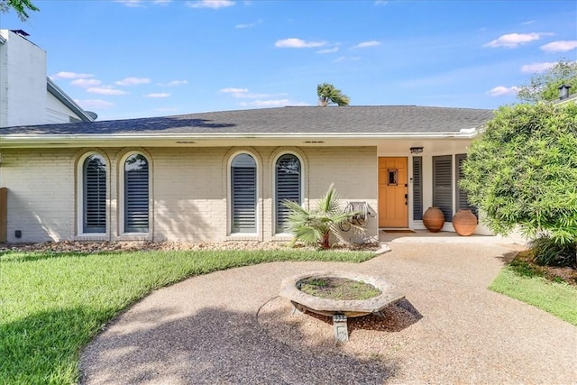 5241 Saint Andrews Dr, Corpus Christi, TX 78413 - view of front facade featuring brick siding, roof with shingles, and a front lawn