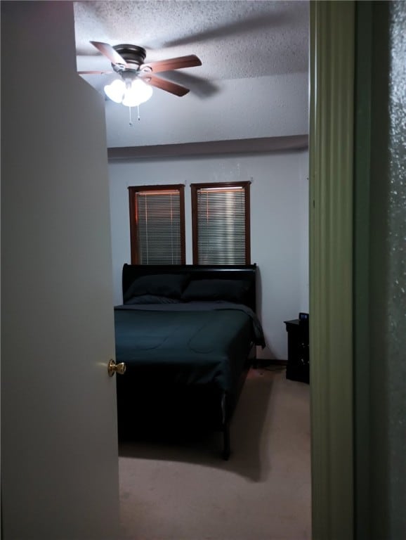 carpeted bedroom with a textured ceiling and ceiling fan