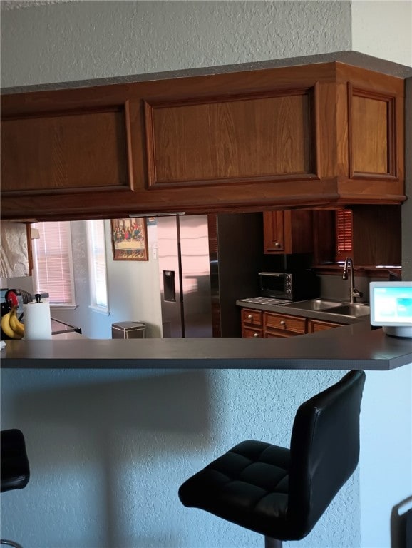 kitchen featuring stainless steel fridge and sink