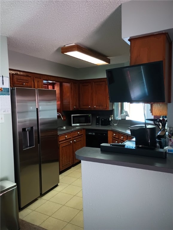 kitchen featuring appliances with stainless steel finishes, sink, light tile patterned floors, kitchen peninsula, and a textured ceiling