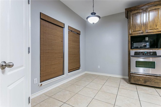 kitchen with stainless steel oven and light tile patterned flooring