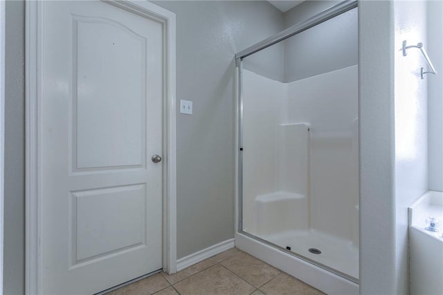 bathroom featuring tile patterned floors and a shower with shower door