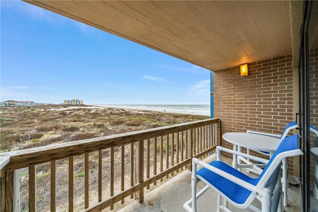 balcony with a water view and a view of the beach