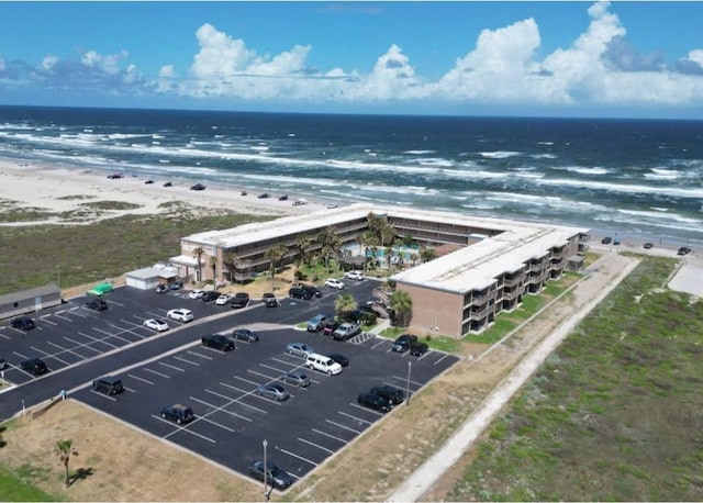 drone / aerial view featuring a water view and a view of the beach