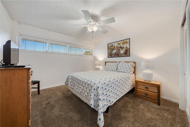 bedroom featuring a closet, ceiling fan, dark colored carpet, and a textured ceiling