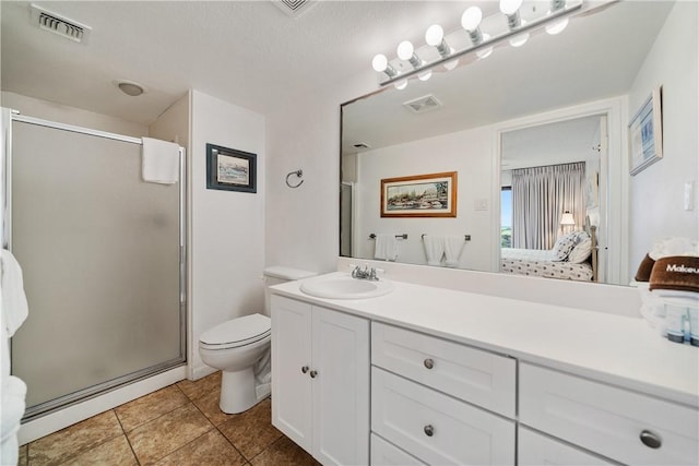 bathroom featuring tile patterned flooring, toilet, walk in shower, and vanity