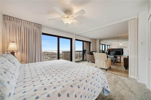 carpeted bedroom with a textured ceiling, access to exterior, and ceiling fan