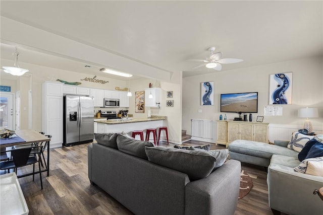 living room with dark hardwood / wood-style flooring and ceiling fan