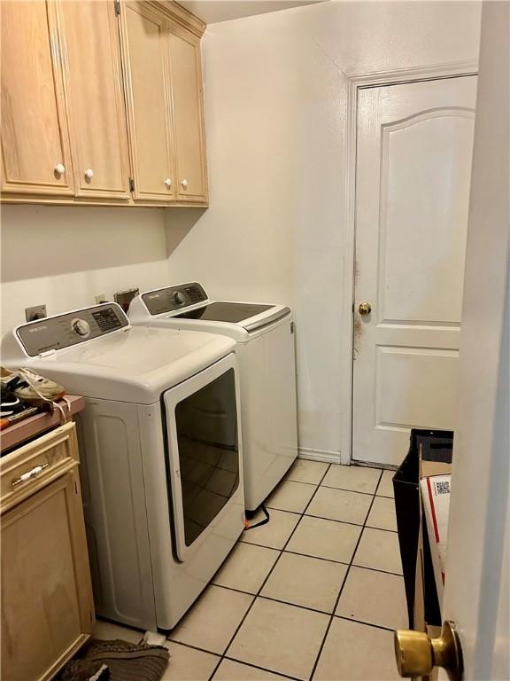 10544 Saddle, Corpus Christi, TX 78410 - washroom with separate washer and dryer, cabinet space, and light tile patterned flooring