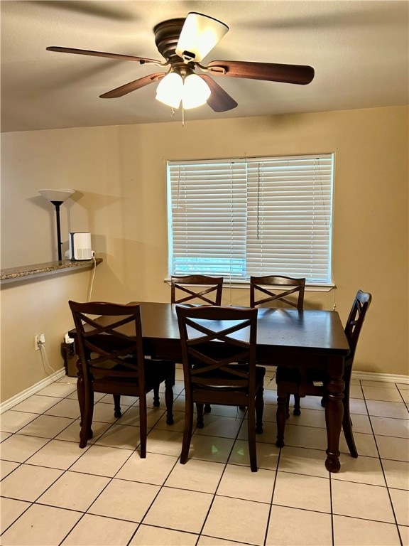 tiled dining space with ceiling fan