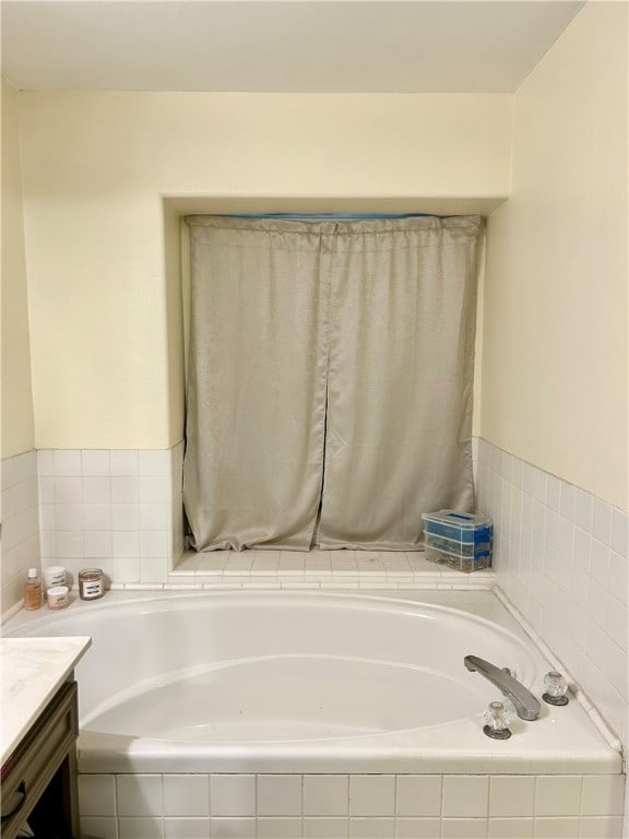 bathroom with tiled bath and vanity