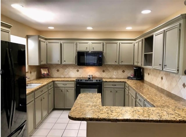 kitchen featuring backsplash, sink, black appliances, and kitchen peninsula