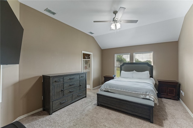 carpeted bedroom with ceiling fan and vaulted ceiling