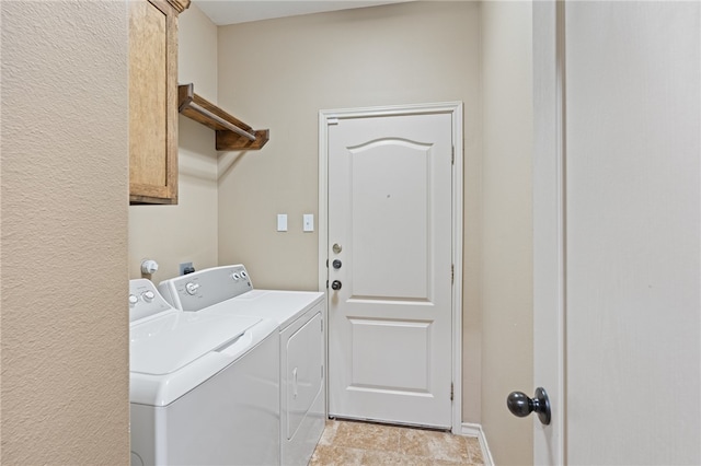 clothes washing area with cabinets and washer and dryer