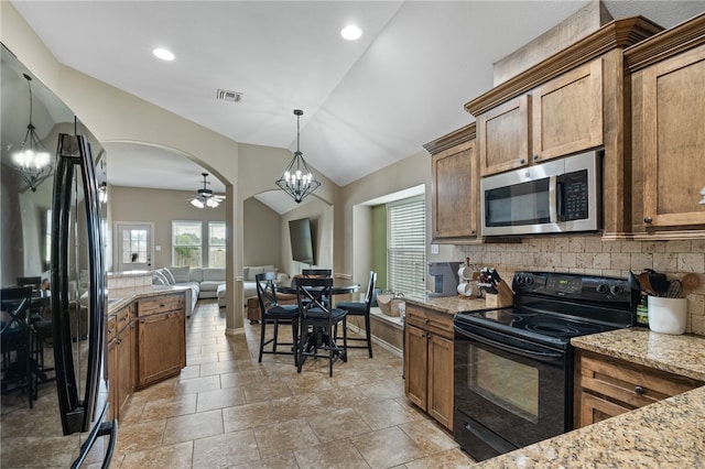 kitchen with ceiling fan with notable chandelier, light stone counters, decorative backsplash, hanging light fixtures, and black appliances