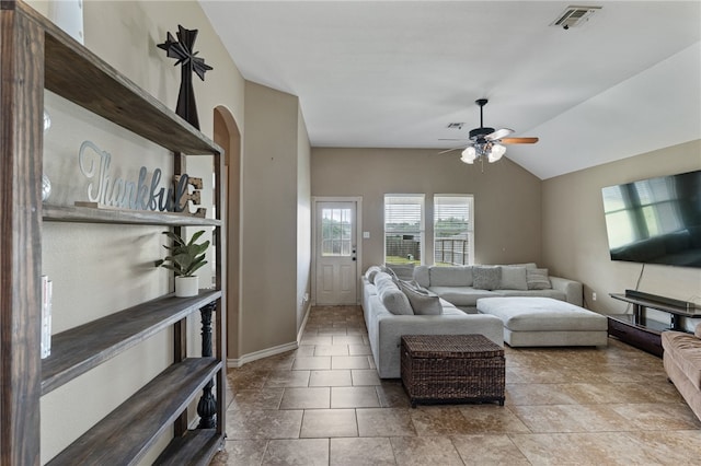 living room featuring ceiling fan, light tile patterned floors, and vaulted ceiling