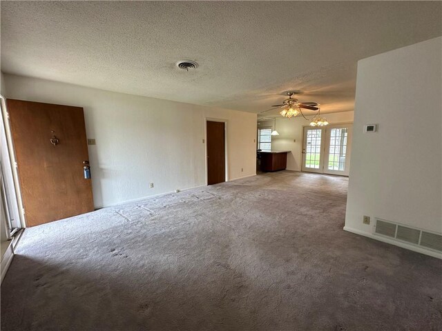1662 Spicewood Dr, Corpus Christi, TX 78412 - unfurnished living room featuring visible vents, baseboards, carpet flooring, and a textured ceiling