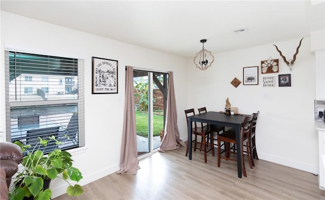 dining area featuring an inviting chandelier and light hardwood / wood-style flooring