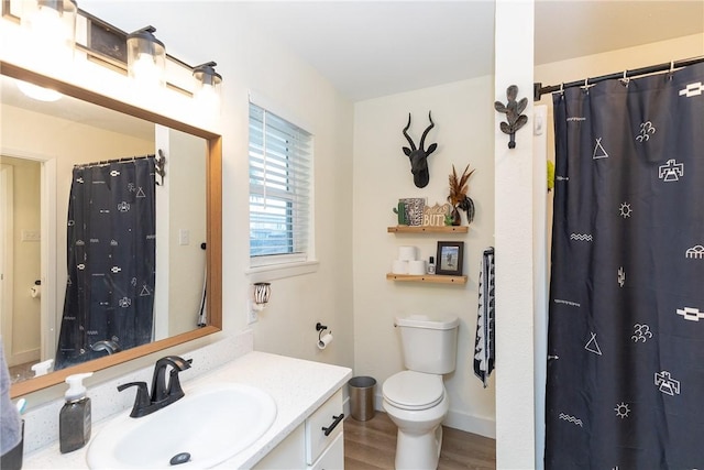 bathroom featuring toilet, hardwood / wood-style floors, vanity, and curtained shower