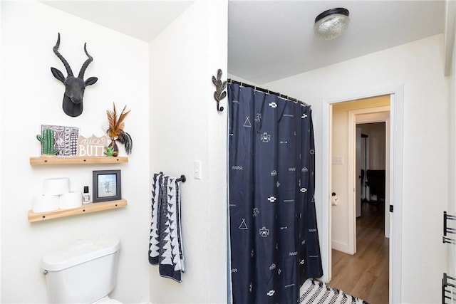 bathroom featuring hardwood / wood-style floors and toilet