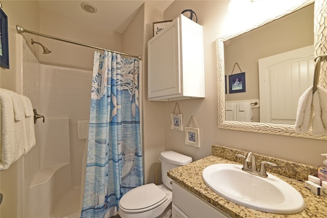 bathroom with a shower with shower curtain, vanity, and toilet