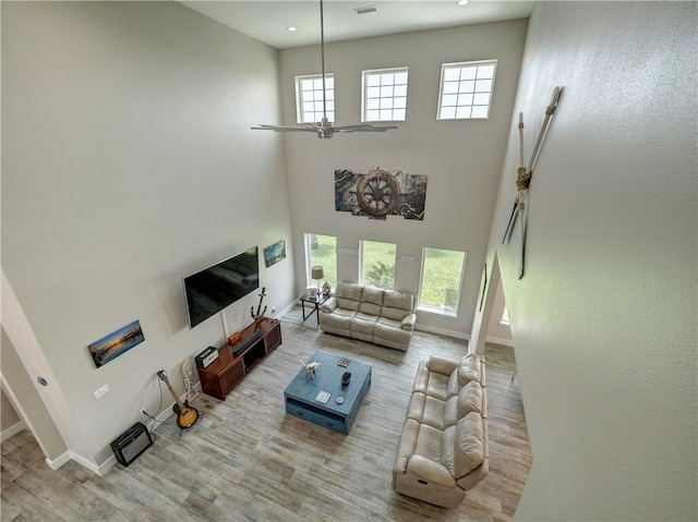 living room featuring light hardwood / wood-style flooring and a high ceiling