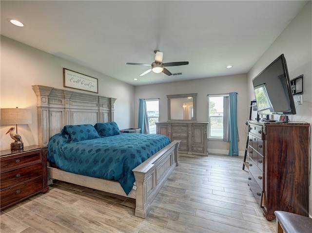 bedroom featuring light hardwood / wood-style flooring, multiple windows, and ceiling fan