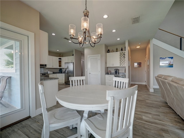 dining area with a notable chandelier and light wood-type flooring