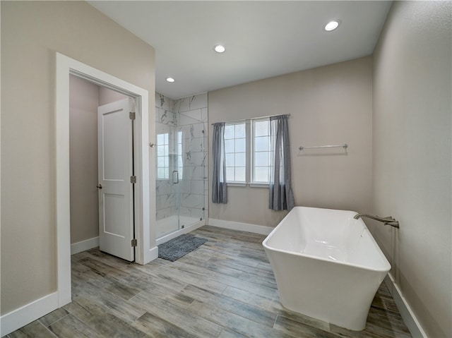 bathroom featuring hardwood / wood-style floors and independent shower and bath