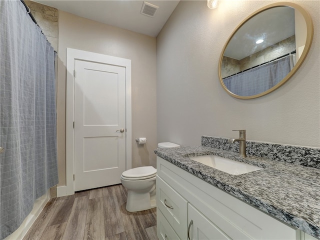 bathroom featuring a shower with shower curtain, hardwood / wood-style floors, vanity, and toilet