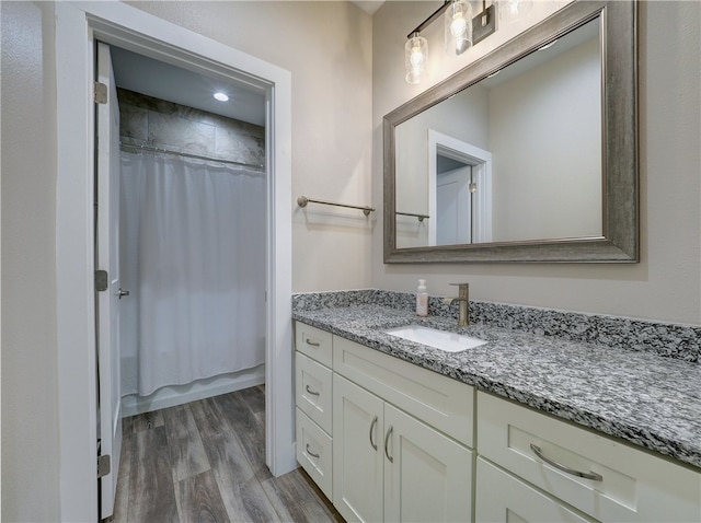 bathroom with wood-type flooring, vanity, and shower / tub combo with curtain