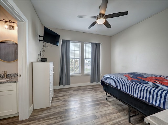 bedroom featuring ceiling fan, light hardwood / wood-style floors, and sink