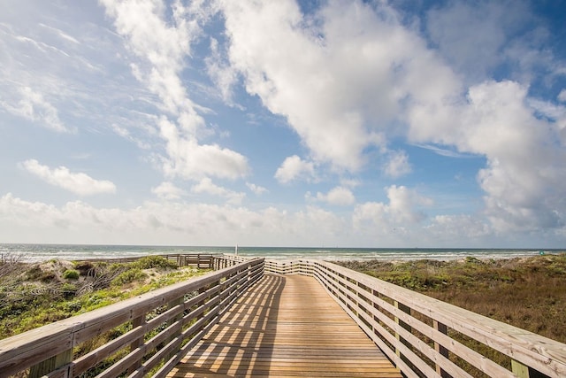 view of home's community with a water view and a beach view