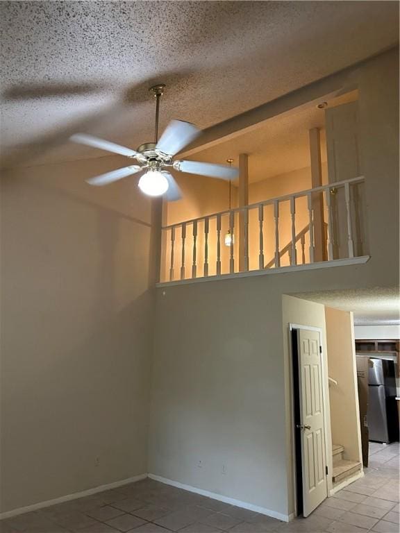 spare room with tile patterned flooring, a textured ceiling, and ceiling fan